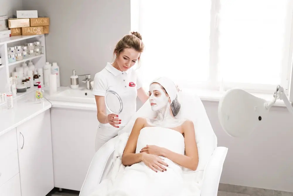 A woman receiving a facial treatment from a clinician