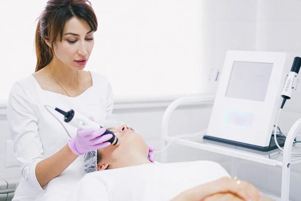 A clinician using a handheld device during a laser treatment